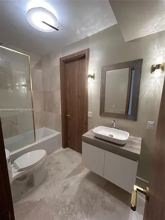 a bathroom with a sink a toilet and shower a mirror
