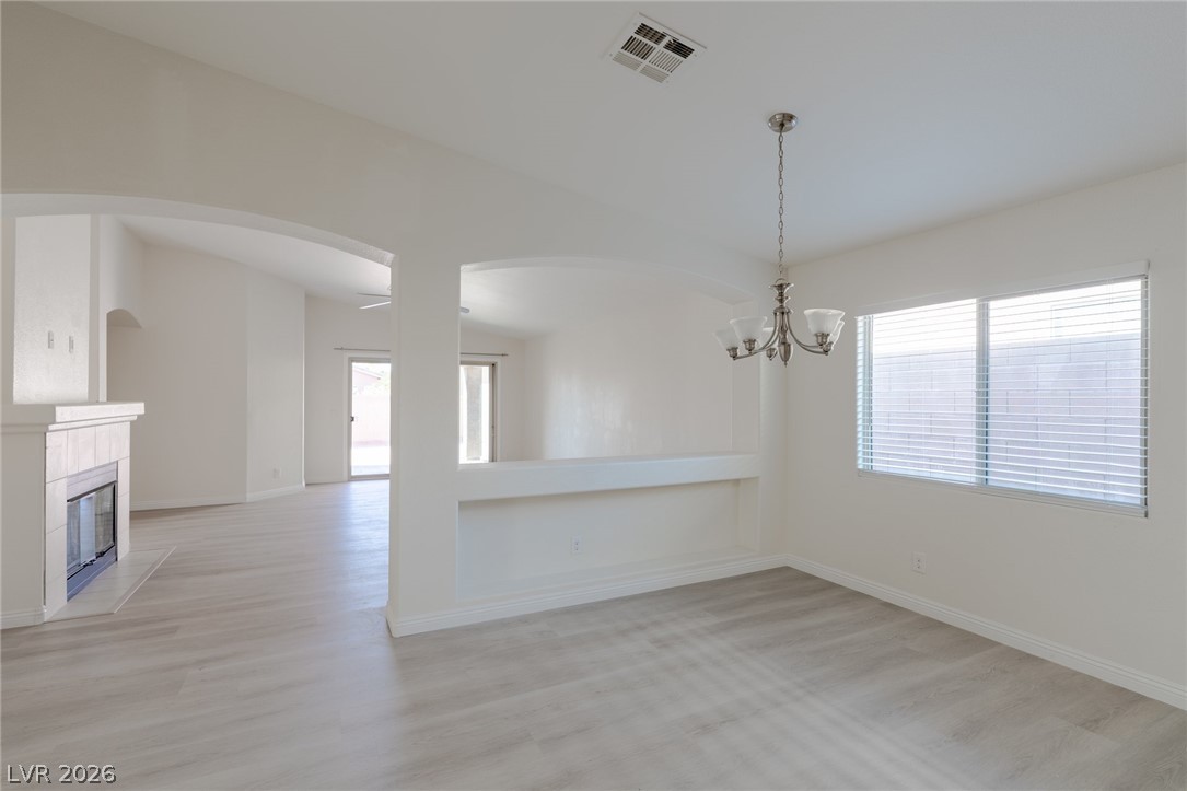8079 Buffalo Ranch Avenue Las Vegas, NV 89147 - Photo 7 of 29 Arched entries and clean wood-look flooring define this open dining space.