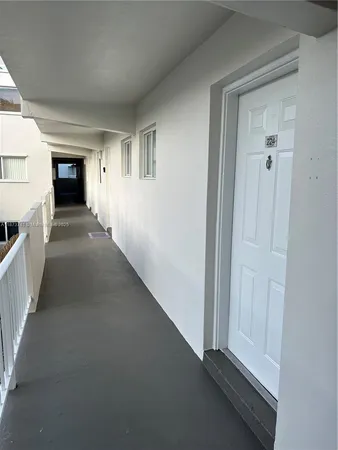 a view of a hallway with wooden floor and a living room
