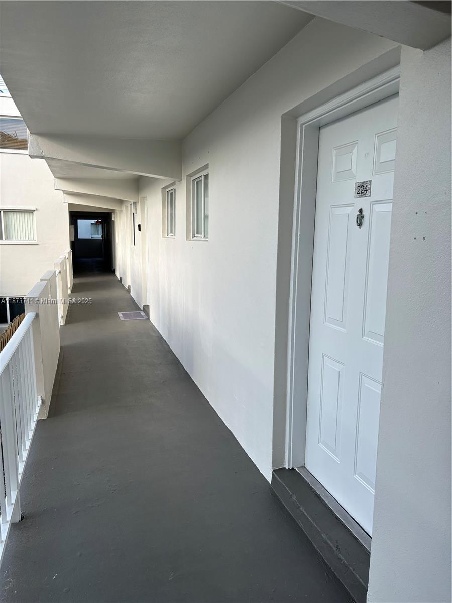 7701 Southwest 88th Street, Unit B224 Miami, FL 33156 - Photo 11 of 14 a view of a hallway with wooden floor and a living room