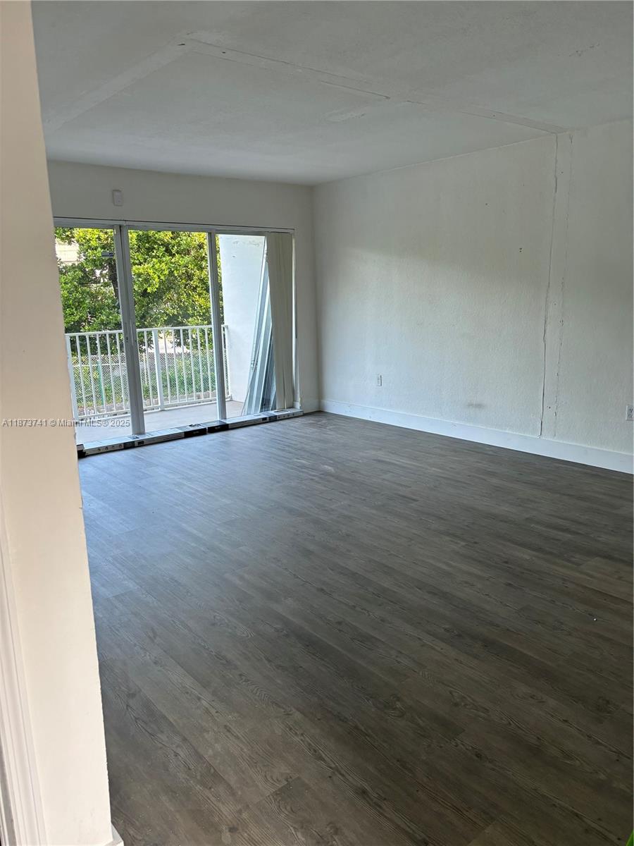 7701 Southwest 88th Street, Unit B224 Miami, FL 33156 - Photo 3 of 14 a view of an empty room with wooden floor and a window