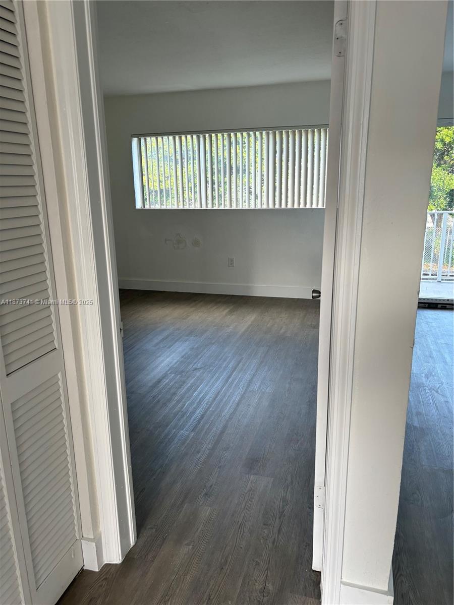 7701 Southwest 88th Street, Unit B224 Miami, FL 33156 - Photo 10 of 14 an empty room with wooden floor and windows