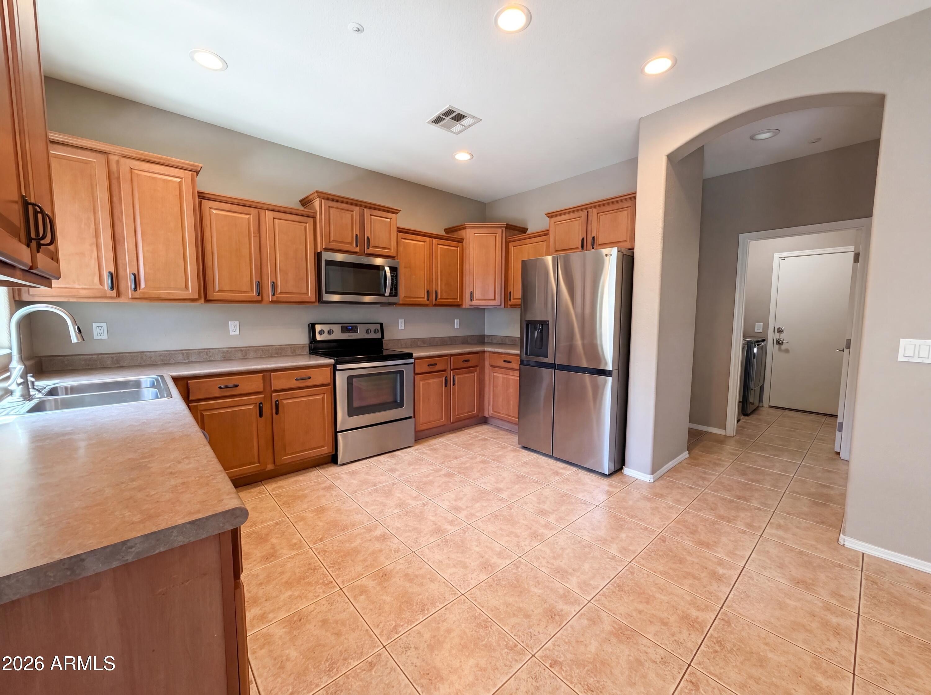 1565 East Hopkins Road Gilbert, AZ 85295 - Photo 18 of 29 a kitchen with stainless steel appliances granite countertop a refrigerator sink and microwave