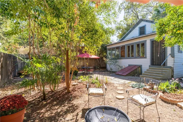 a kitchen with stainless steel appliances granite countertop a refrigerator a sink dishwasher a dining table and chairs with wooden floor