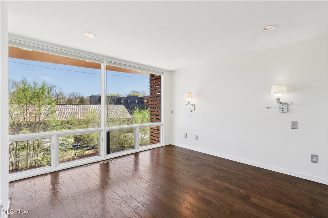 1852 Coltman Road Cleveland, OH 44106 - Photo 18 of 39 Primary bed room featuring floor to ceiling windowa, wood floors, baseboards, and recessed lighting