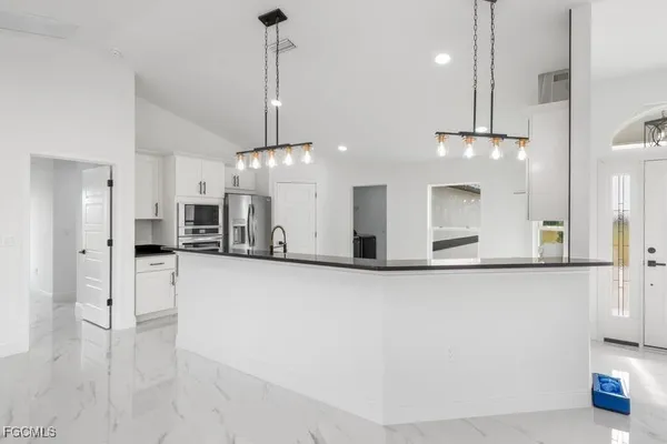 a view of a kitchen with a refrigerator a microwave and a sink