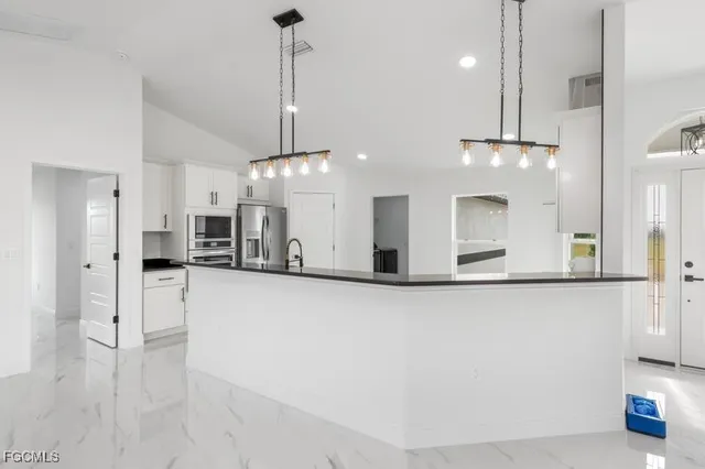 a view of a kitchen with a refrigerator a microwave and a sink