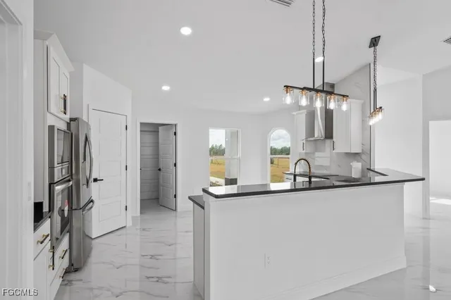 a kitchen with stainless steel appliances a sink and a refrigerator