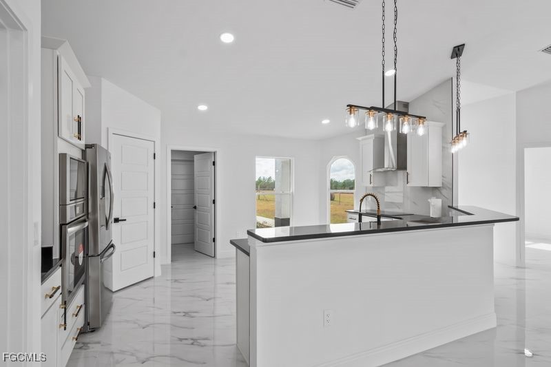 14461 Southeast 80th Street Morriston, FL 32668 - Photo 12 of 37 a kitchen with stainless steel appliances a sink and a refrigerator