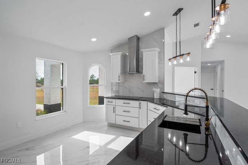 14461 Southeast 80th Street Morriston, FL 32668 - Photo 14 of 37 a kitchen with granite countertop a stove a sink a dining table and chairs