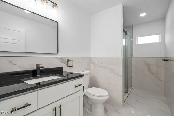 a bathroom with a sink a toilet and shower