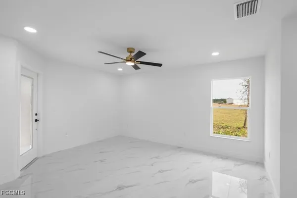 an empty room with a window and a ceiling fan