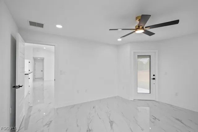 an empty room with closet and a ceiling fan