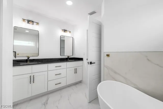 a bathroom with a granite countertop sink and a mirror