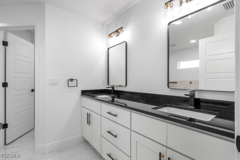 14461 Southeast 80th Street Morriston, FL 32668 - Photo 29 of 37 a bathroom with a granite countertop sink and a mirror