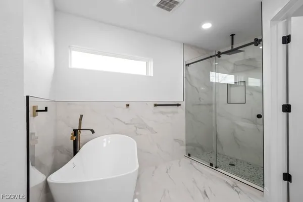 a bathroom with a bathtub and shower