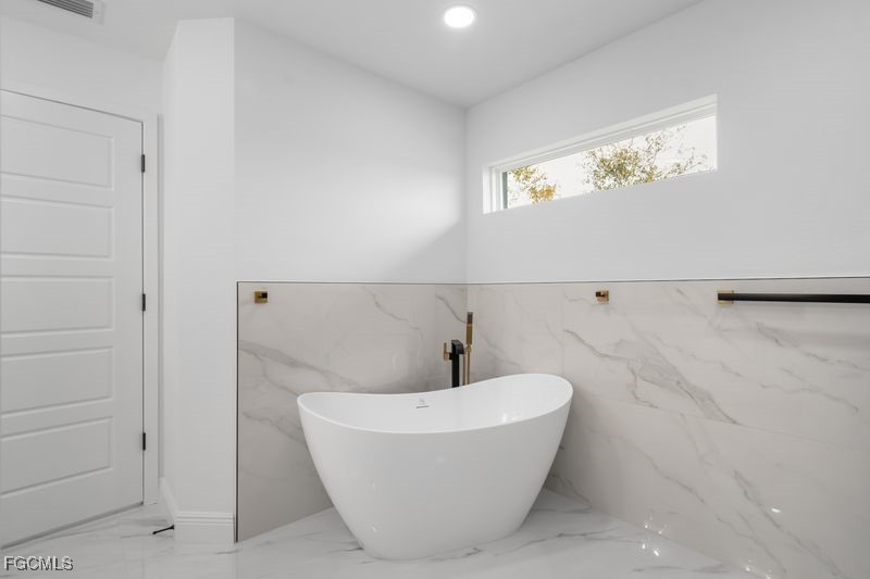 14461 Southeast 80th Street Morriston, FL 32668 - Photo 31 of 37 a bathroom with a bathtub and shower