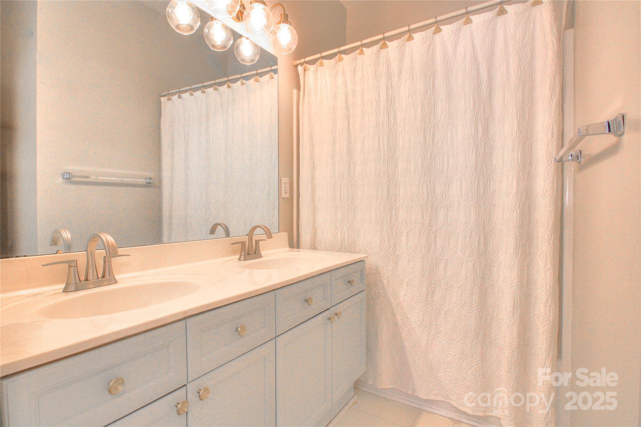 8414 Bampton Drive Concord, NC 28027 - Photo 24 of 32 a bathroom with a double vanity sink and a mirror