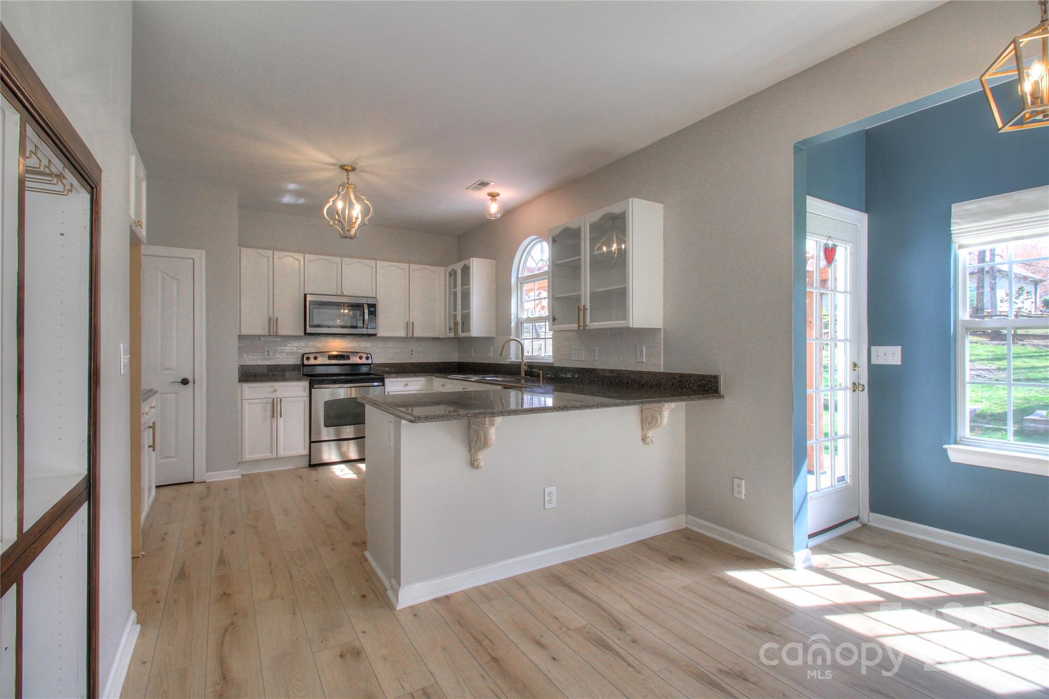 8414 Bampton Drive Concord, NC 28027 - Photo 4 of 32 a kitchen with granite countertop white cabinets and appliances