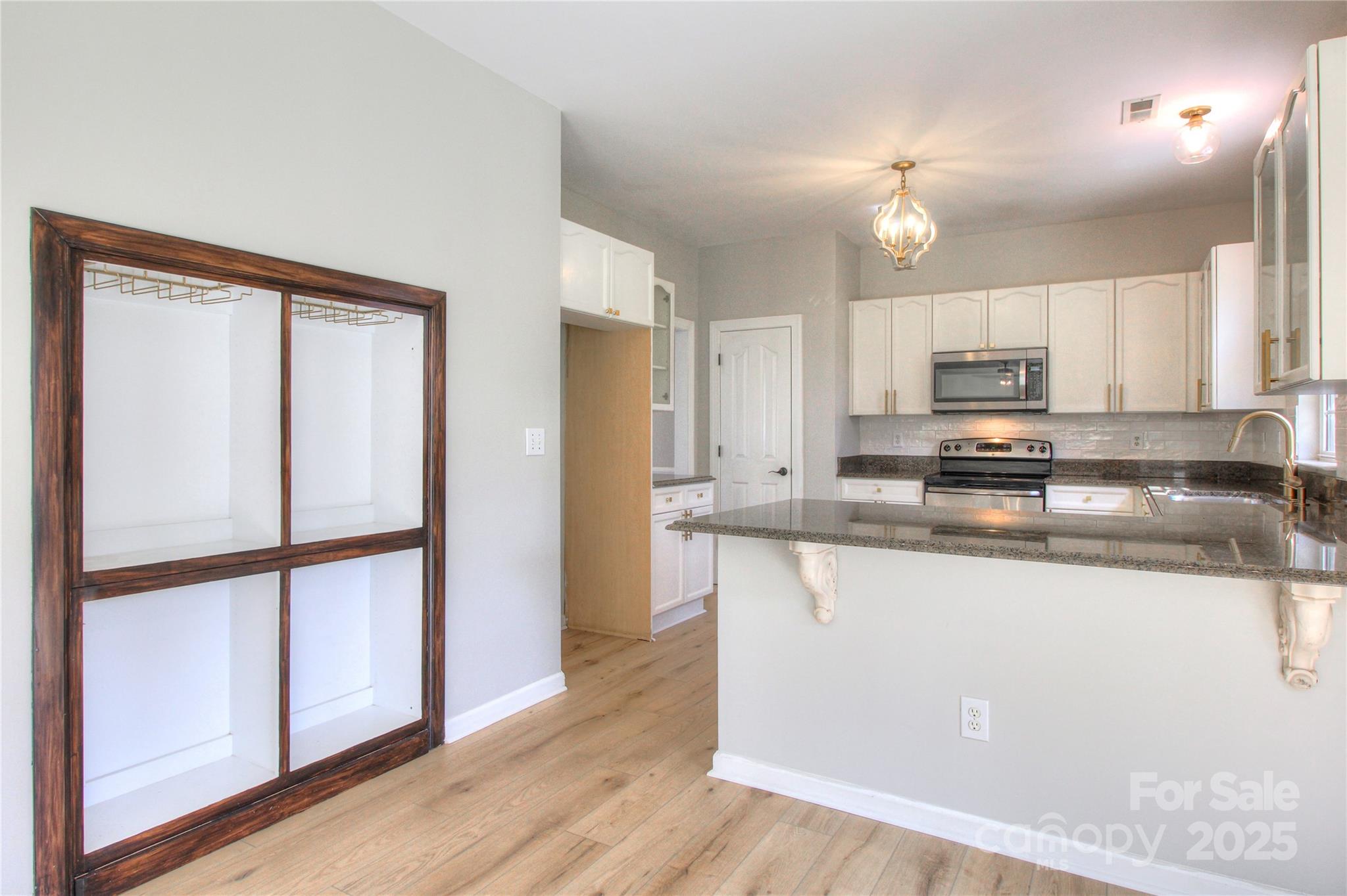 8414 Bampton Drive Concord, NC 28027 - Photo 5 of 32 a kitchen with stainless steel appliances granite countertop a refrigerator a stove a sink and a microwave