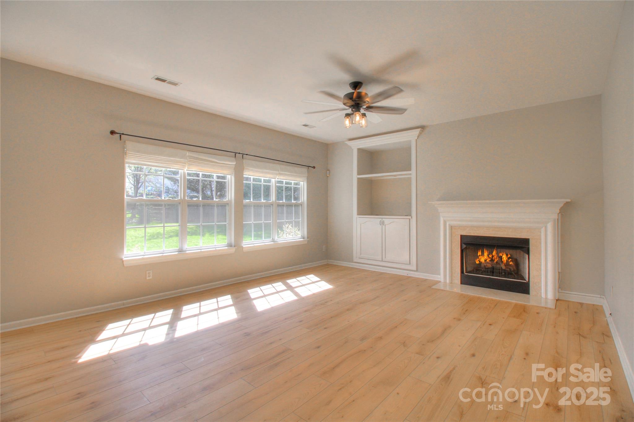 8414 Bampton Drive Concord, NC 28027 - Photo 6 of 32 a view of an empty room with a window and a fireplace