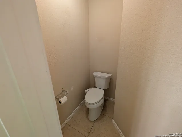a white toilet sitting next to a white wall