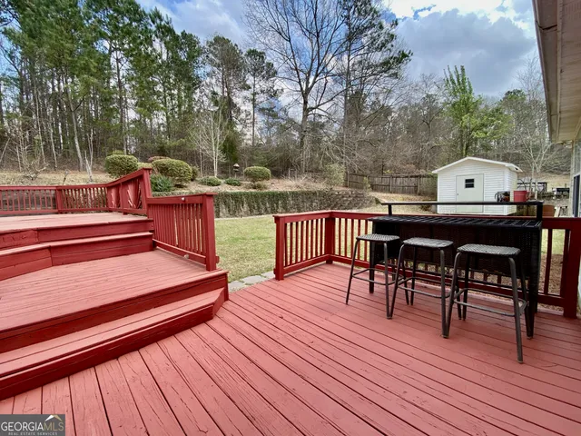 a balcony with wooden floor table and chairs