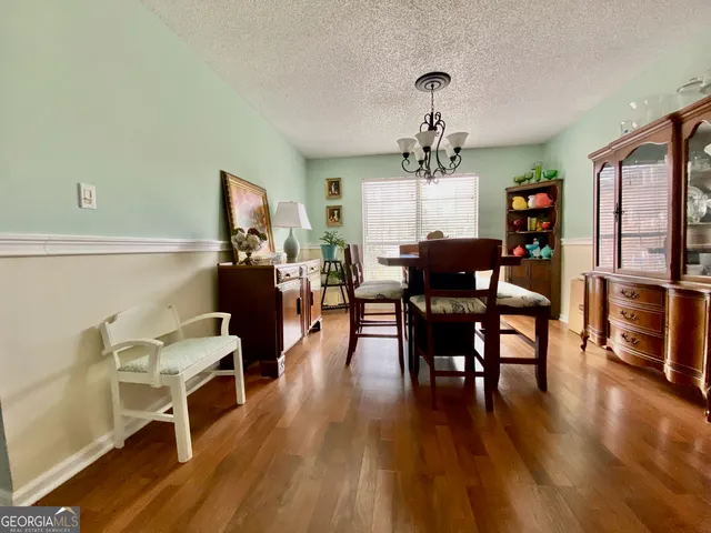 a view of a dining room with furniture wooden floor and chandelier