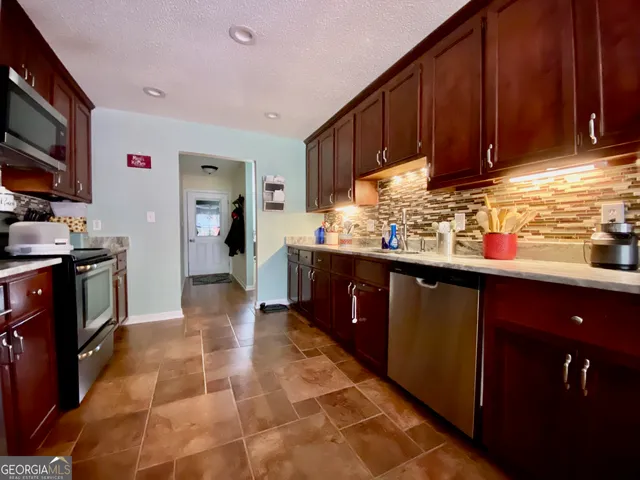 a kitchen with stainless steel appliances granite countertop a sink stove and cabinets