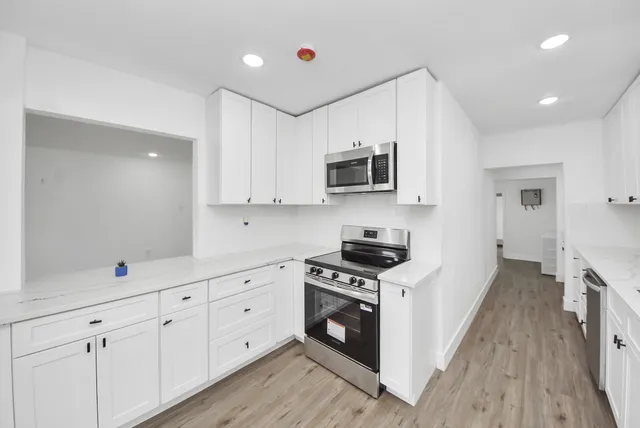 a view of an empty room with wooden floor