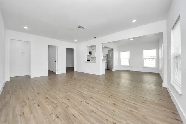 a view of storage and utility room with wooden floor and windows