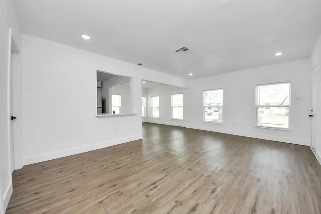 a view of an empty room with wooden floor