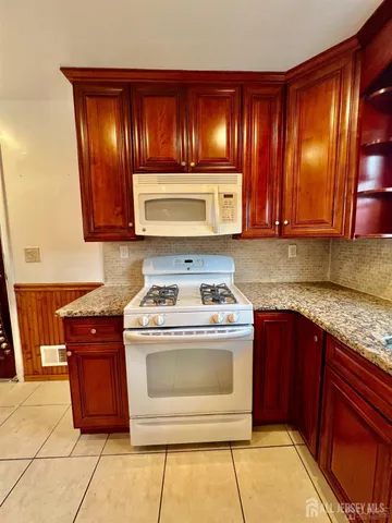 a kitchen with granite countertop cabinets and stove top oven