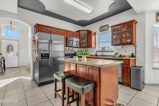 a kitchen with stainless steel appliances granite countertop a refrigerator and a stove top oven