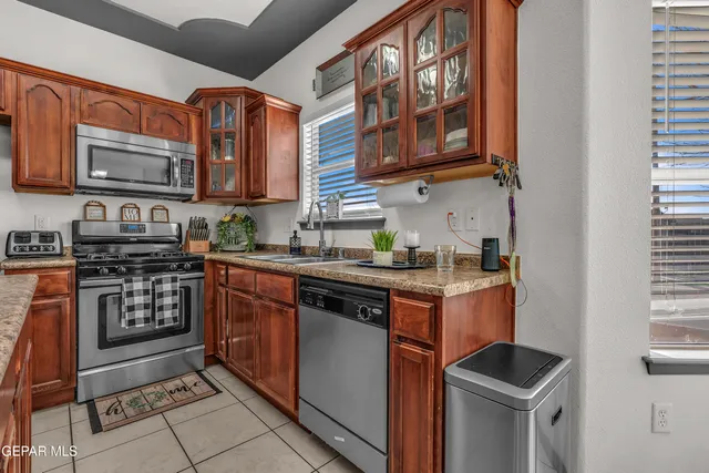 a kitchen with stainless steel appliances granite countertop a stove top oven a sink dishwasher and cabinets with wooden floor