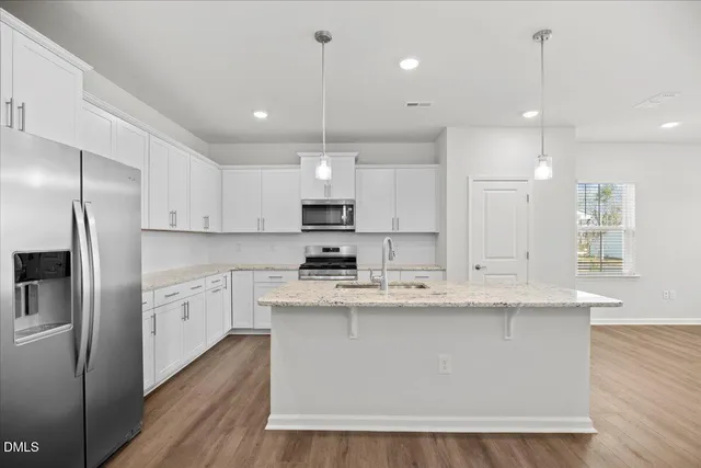 a view of a kitchen with wooden floor and electronic appliances