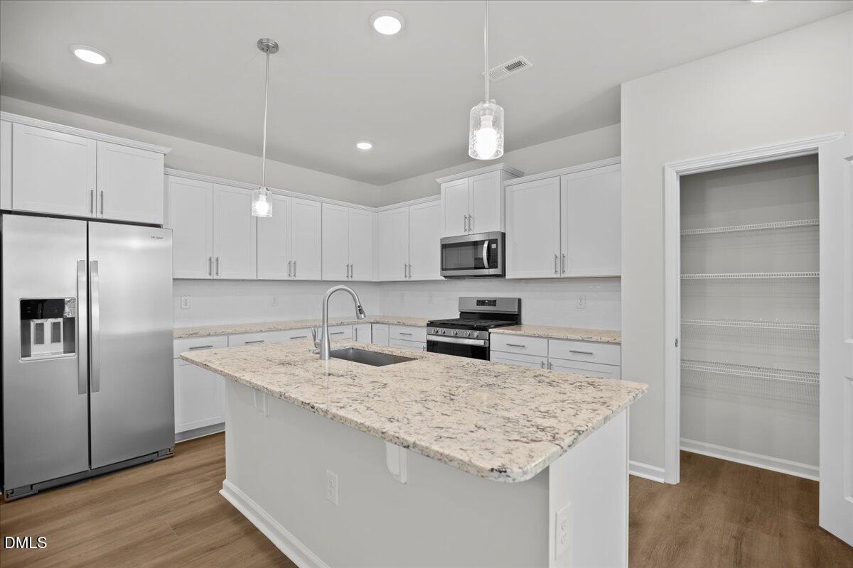 373 Fosterton Cottage Way Raleigh, NC 27603 - Photo 10 of 42 a kitchen with stainless steel appliances granite countertop a sink refrigerator and microwave