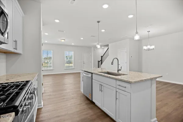 a kitchen with stainless steel appliances granite countertop white cabinets a sink and dishwasher