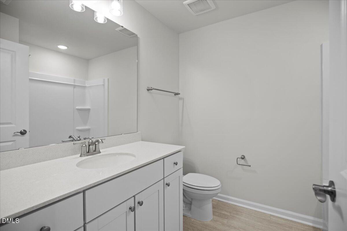 373 Fosterton Cottage Way Raleigh, NC 27603 - Photo 34 of 42 a bathroom with a granite countertop sink a toilet and a mirror