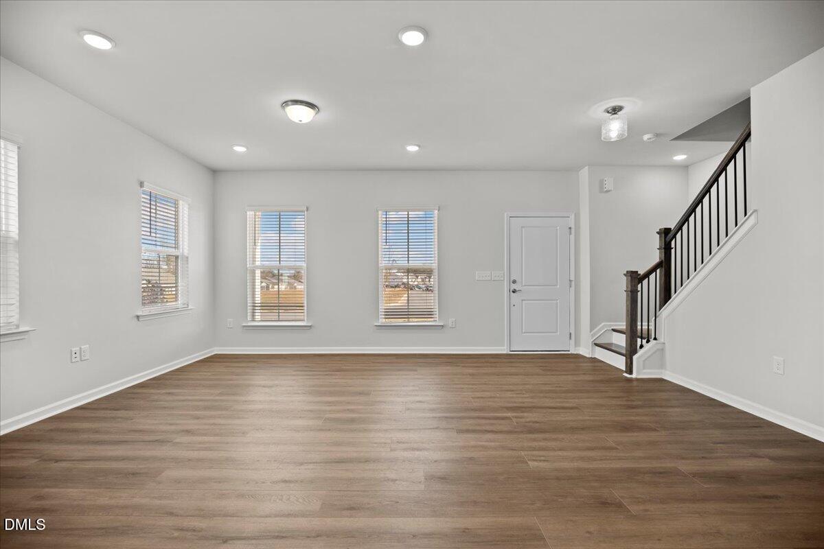 373 Fosterton Cottage Way Raleigh, NC 27603 - Photo 7 of 42 a view of an empty room with wooden floor and a window