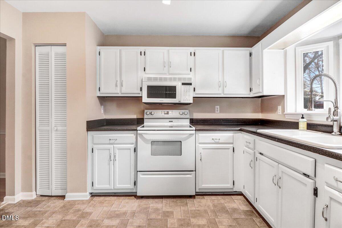 5738 3 Oaks Drive Raleigh, NC 27612 - Photo 10 of 32 a kitchen with cabinets appliances and a window