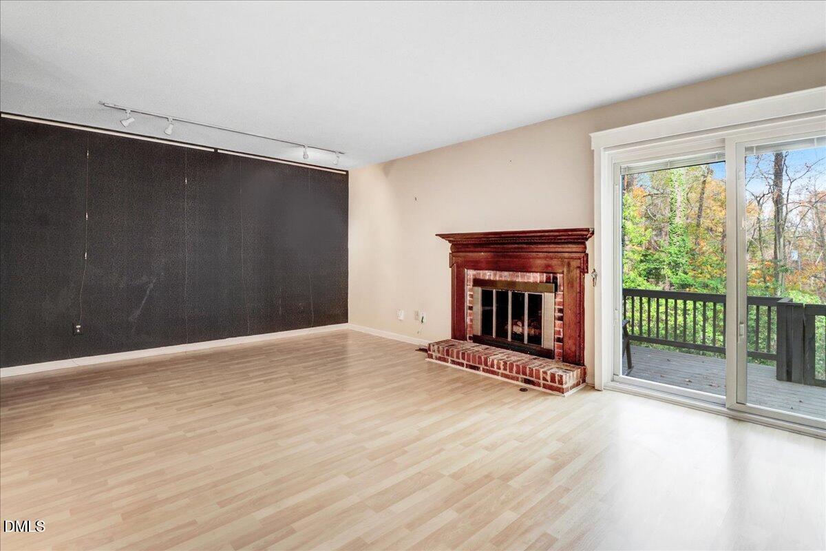 5738 3 Oaks Drive Raleigh, NC 27612 - Photo 14 of 32 a view of an empty room with wooden floor and a fireplace