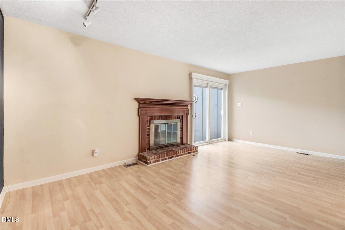 5738 3 Oaks Drive Raleigh, NC 27612 - Photo 15 of 32 a view of an empty room with a fireplace and a window