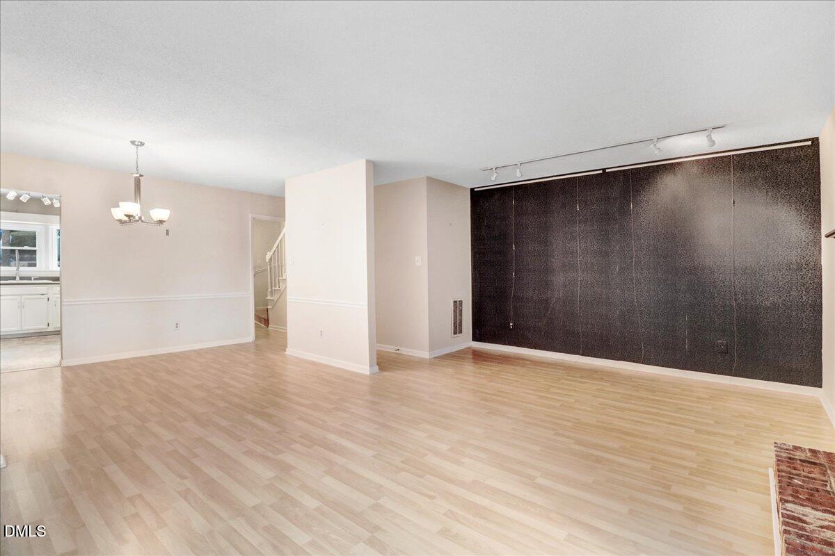 5738 3 Oaks Drive Raleigh, NC 27612 - Photo 17 of 32 a view of an empty room with wooden floor