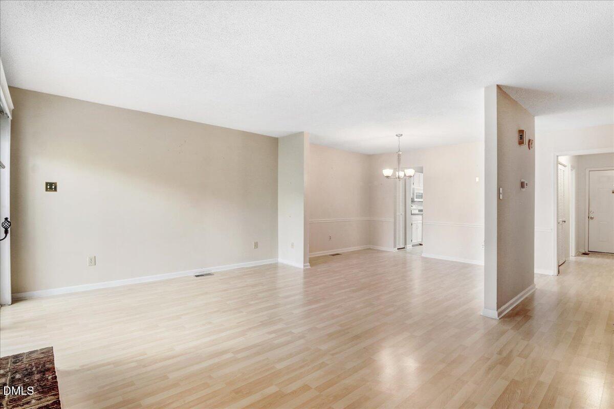 5738 3 Oaks Drive Raleigh, NC 27612 - Photo 18 of 32 a view of an empty room with wooden floor