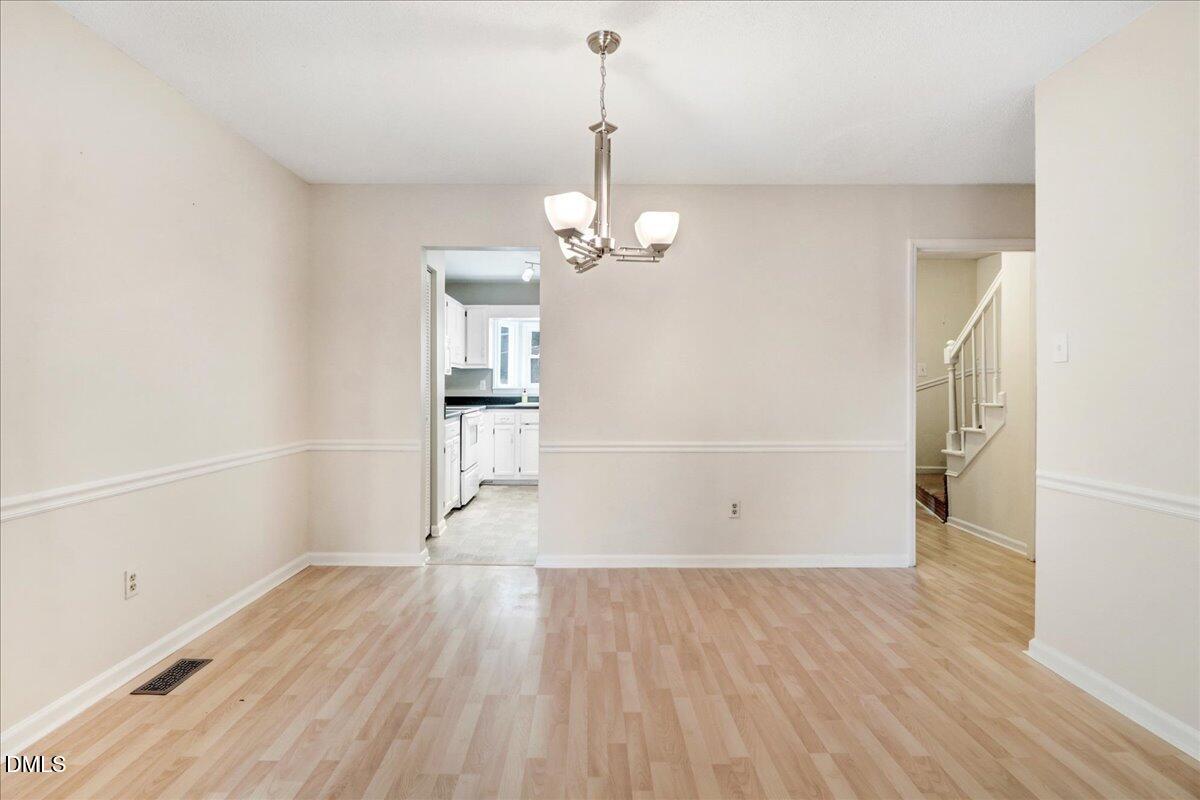 5738 3 Oaks Drive Raleigh, NC 27612 - Photo 20 of 32 an empty room with wooden floor and windows