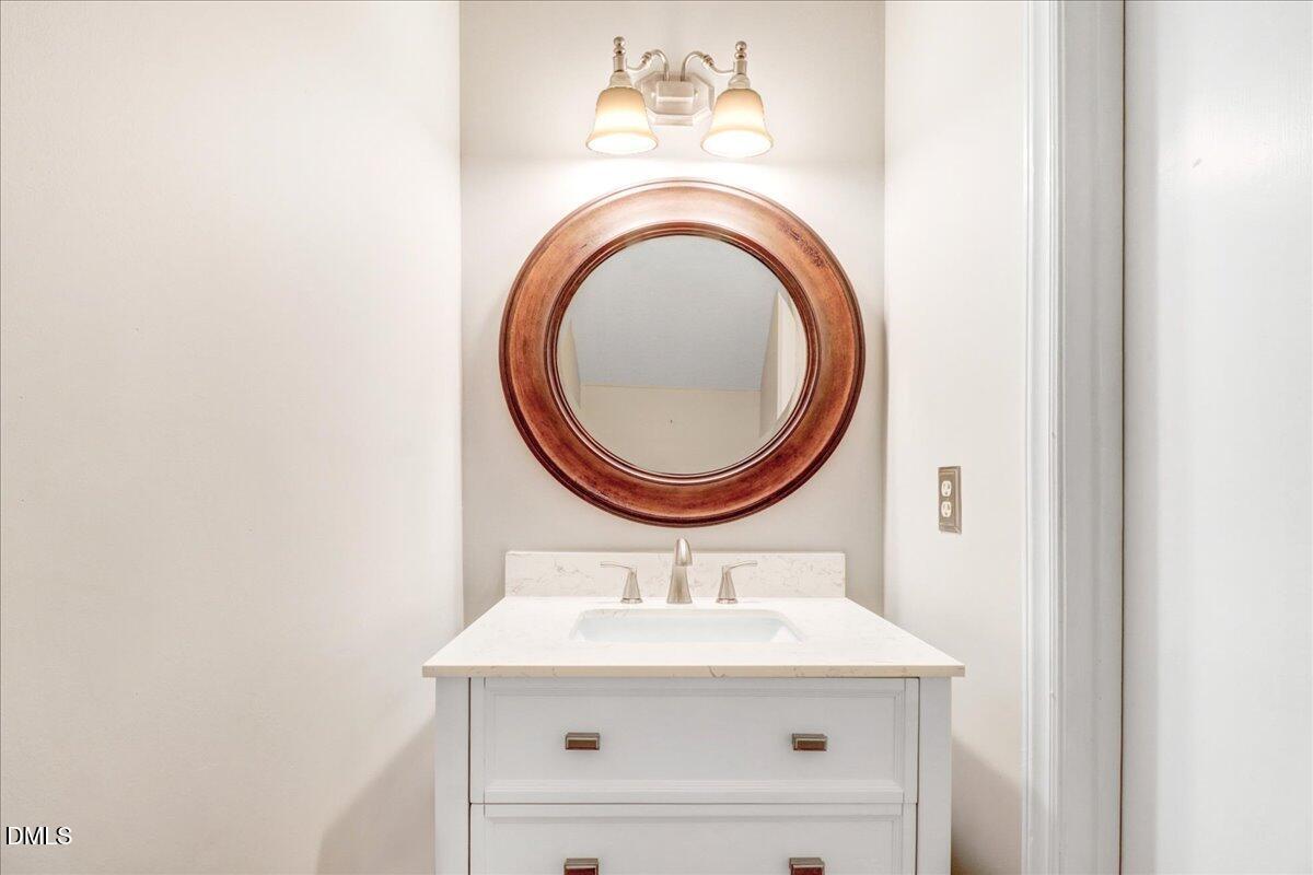 5738 3 Oaks Drive Raleigh, NC 27612 - Photo 21 of 32 a bathroom with a sink a mirror and a toilet