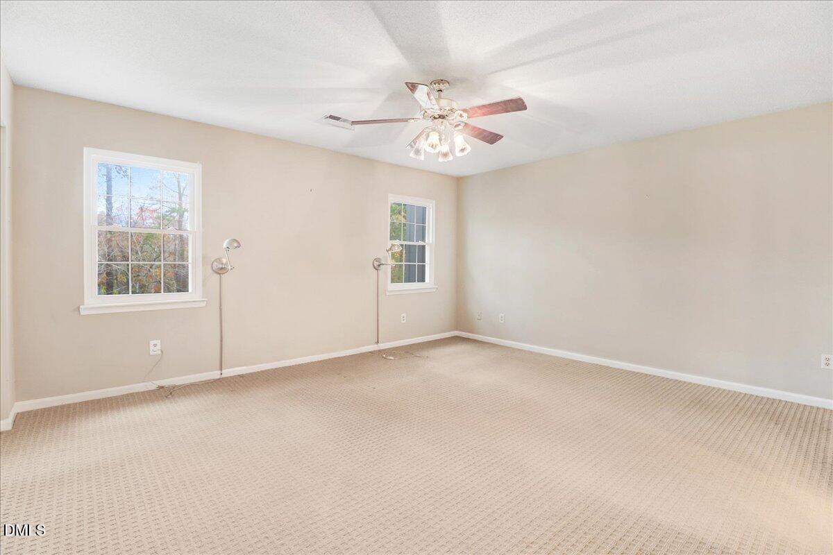 5738 3 Oaks Drive Raleigh, NC 27612 - Photo 24 of 32 an empty room with windows and fan