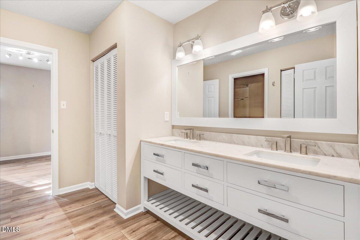 5738 3 Oaks Drive Raleigh, NC 27612 - Photo 27 of 32 a bathroom with a double vanity sink and mirror