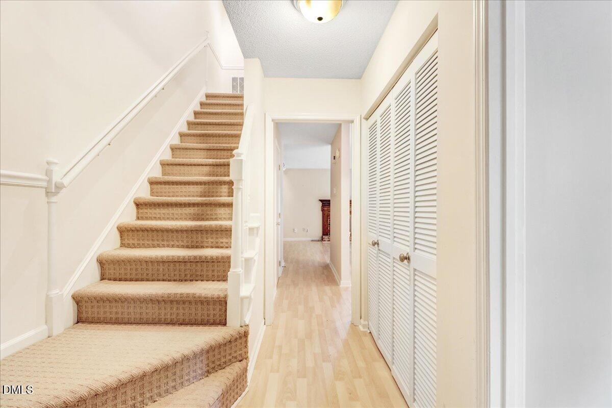 5738 3 Oaks Drive Raleigh, NC 27612 - Photo 5 of 32 a view of a hallway with wooden floor and staircase